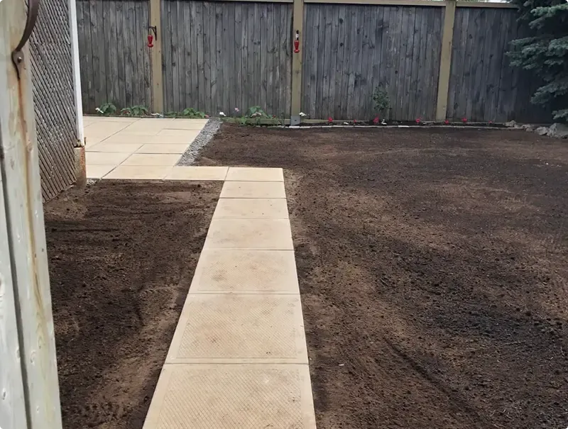 Slab walkway through graded topsoil prepared for new sod