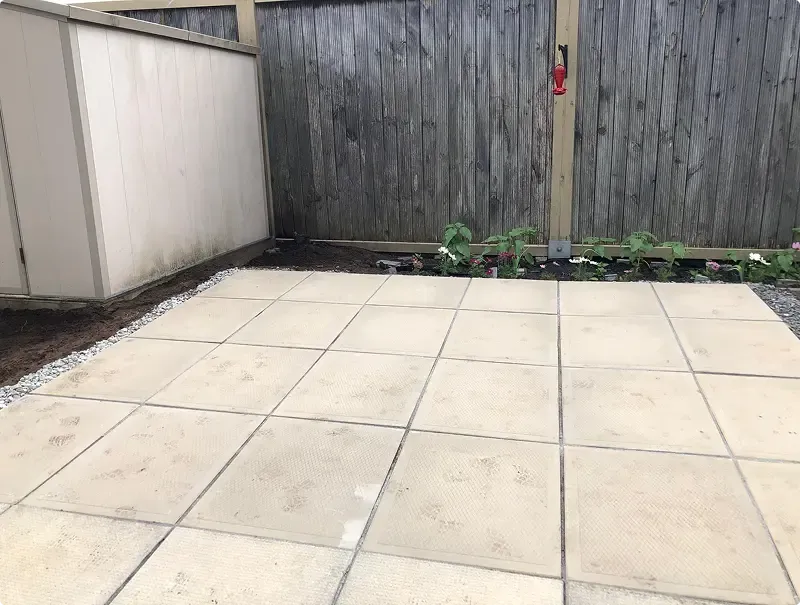 Square patio slabs and a new planting bed in a fenced Toronto backyard